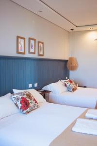 two beds in a hotel room with white sheets at Tramonto hotel & ristorante in Empedrado