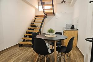 a dining room with a table and chairs and a staircase at Departamentos A&B in Resistencia +6 photos