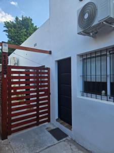 a building with a gate and a door with a fan at Departamentos A&B in Resistencia
