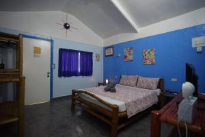 a bedroom with a bed and a blue wall at Sun House Rental in Mambajao