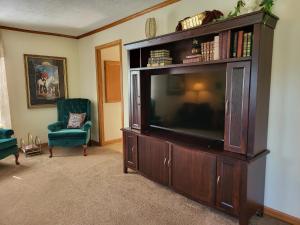 a living room with a large entertainment center with a television at Pondview Escape a 75-Acre Retreat in Marion