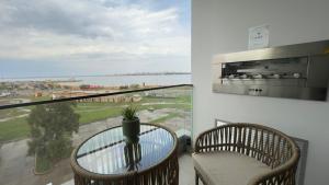 a balcony with a table and a view of the water at LUXER VIVO Encarnacion in Encarnación