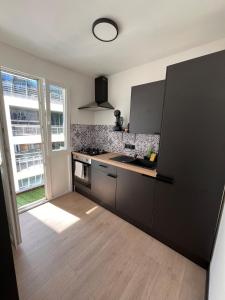 a kitchen with a stove and a counter top at Studio moderne et confort - Guillemins in Liège
