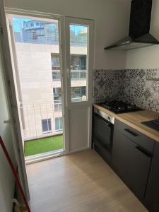 a kitchen with a stove and a window at Studio moderne et confort - Guillemins in Liège +3 photos