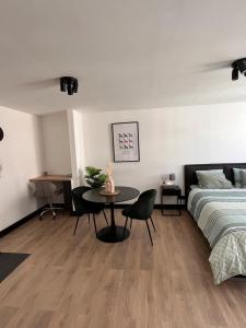 a bedroom with a bed and a table next to a bed at Studio moderne et confort - Guillemins in Liège