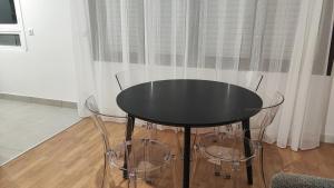 a black table and two chairs in a room at Charming Bagneux Nest in Bagneux +1 photo