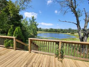 a wooden deck with a view of a lake at Pondview Escape a 75-Acre Retreat in Marion