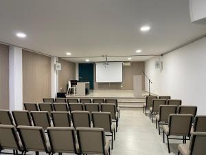 an empty lecture room with chairs and a white screen at Colon Plaza Hotel in Tumaco