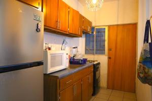 a kitchen with wooden cabinets and a white microwave at Entire accommodation in Bahia de la Paz in La Paz