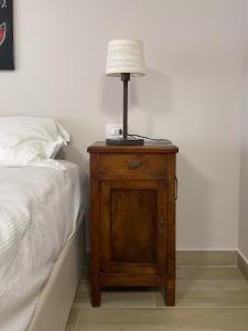 a lamp on a wooden night stand next to a bed at Mama Lidia in Creazzo