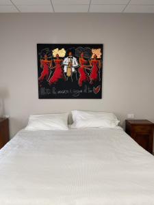 a bedroom with a white bed with a poster on the wall at Mama Lidia in Creazzo +49 photos