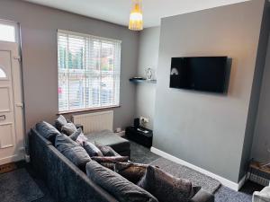 a living room with a couch and a flat screen tv at House in Hemingfield, Ideal for Contractors and Long Stays in Wombwell