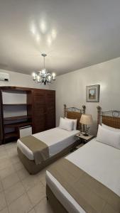 a bedroom with two beds and a chandelier at Hotel Fazenda Lagoa Grande in Sete Lagoas +109 photos