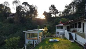a house with a yard with a boat on the grass at La Enamorada Cabañas & Resort in Zacatlán