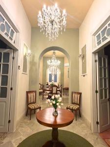 ein Wohnzimmer mit Tisch, Stühlen und Kronleuchter in der Unterkunft Casa Ku'x in Mérida