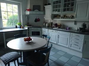 a kitchen with a table with a bowl of fruit on it at Doppelzimmer mit Gartenblick in Reckershausen +3 photos