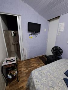 a bedroom with a bed and a tv on the wall at Só pra Dormir centro in Brotas
