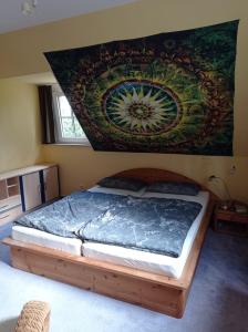 a bedroom with a bed with a painting on the wall at Doppelzimmer mit Gartenblick in Reckershausen