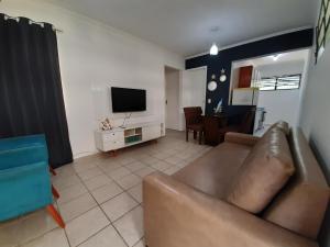 ein Wohnzimmer mit Sofa und Fernseher in der Unterkunft Bate & Volta - Apartamentos com 2 quartos próximo ao SESC Bertioga in Bertioga