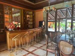 a bar in a restaurant with a table and chairs at Hotel Fazenda Lagoa Grande in Sete Lagoas