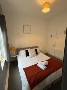 a bedroom with a large bed with a red blanket at Elegance apartments in West Cornforth