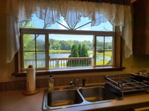 a kitchen sink with a window with a view of a lake at Pondview Escape a 75-Acre Retreat in Marion