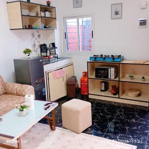 a living room with a table and a microwave at Les studios américains d'Angré - 2 in Mandanou