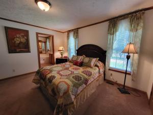 a bedroom with a bed and a lamp and a window at Pondview Escape a 75-Acre Retreat in Marion