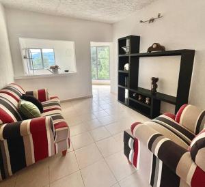 a living room with two couches and a flat screen tv at La Enamorada Cabañas & Resort in Zacatlán