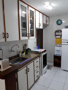 a kitchen with a sink and a refrigerator at Triplex com Piscina no Peró - Perto da Praia in Cabo Frio