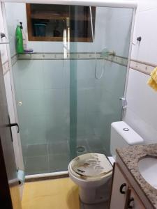 a bathroom with a toilet and a glass shower at Triplex com Piscina no Peró - Perto da Praia in Cabo Frio +21 photos