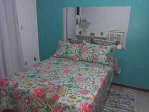 a bedroom with a bed with a colorful comforter and pillows at Triplex com Piscina no Peró - Perto da Praia in Cabo Frio