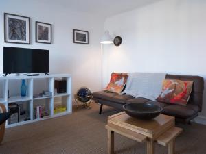a living room with a couch and a tv at Harbour View in Aberaeron