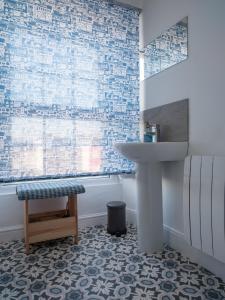 a bathroom with a sink and a table and a stool at Harbour View in Aberaeron +23 photos