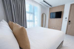 a bedroom with a white bed and a large window at Delamar Hotel in San Andrés