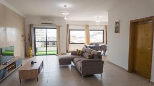 a living room with a couch and a tv at Appart Congo-Warf- vue mer in Pointe-Noire