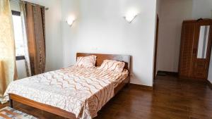 a bedroom with a bed with a wooden headboard at Appart Congo-Warf- vue mer in Pointe-Noire