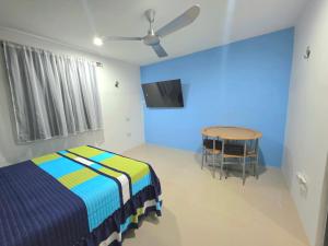 a bedroom with a bed and a table and a ceiling fan at Sweethome Mérida in Mérida