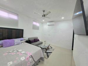 a bedroom with a bed and a ceiling fan at Sweethome Mérida in Mérida