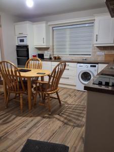 a kitchen with a wooden table and chairs in a kitchen at John's Farmhouse in Kilrush