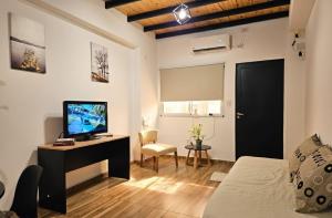 a bedroom with a bed and a tv and a desk at Departamentos A&B in Resistencia