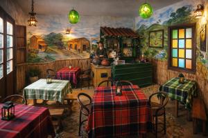 a restaurant with tables and a kitchen with a mural at Casona Rosa Lorenza in Corrales