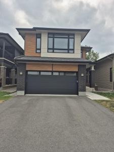 a large house with a garage in a driveway at The Creek Home in Kemptville