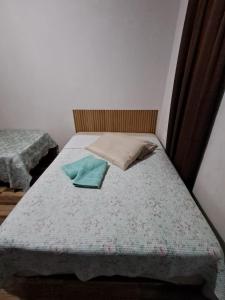 a small bedroom with a bed with a blue blanket at Suite Nomar centro in Brotas