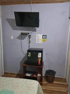 a room with a bed and a television on a wall at Suite Nomar centro in Brotas +6 photos