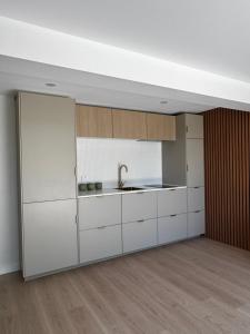 an empty kitchen with white cabinets and a sink at Luxury self-contained guest suite in Gold Coast +5 photos