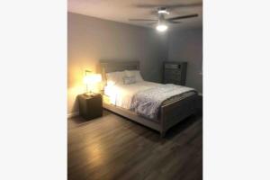 a bedroom with a bed and a lamp on a wooden floor at 3Bed 2Bath PRIVATE HOME Decatur in Decatur