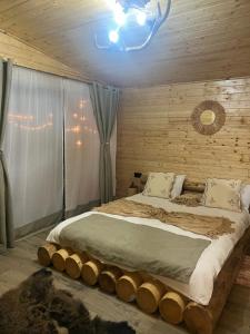 a bedroom with a large bed made out of logs at Cabana A Vic in Taşca