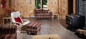a living room with a stove and chairs at Les Chalets du Lac Serein (Ludger) in Saint Ludger de Milot