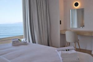 a hotel room with a bed with towels and a window at 9 Muses Apartments in Agios Nikolaos